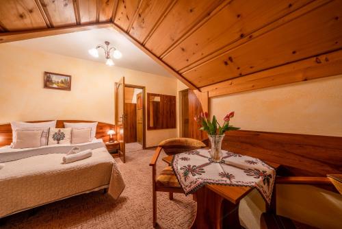a bedroom with a bed and a table in a room at Willa u Zwijaczy in Zakopane