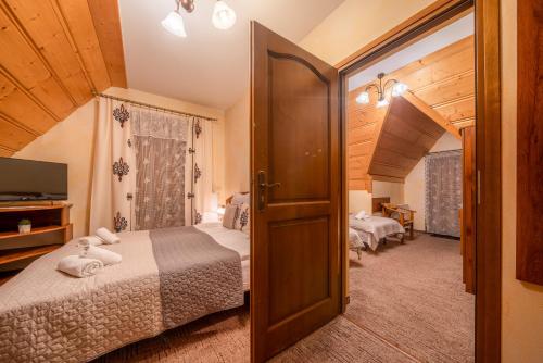 a bedroom with two beds and a sliding door at Willa u Zwijaczy in Zakopane
