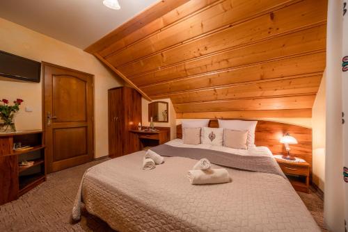 a bedroom with a large bed with wooden ceilings at Willa u Zwijaczy in Zakopane