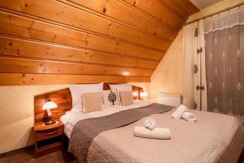 a bedroom with a bed with two towels on it at Willa u Zwijaczy in Zakopane