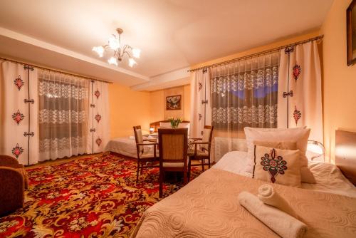 a hotel room with a bed and a table at Willa u Zwijaczy in Zakopane