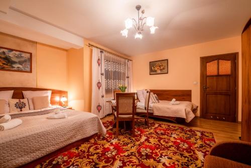 a bedroom with two beds and a table and a chair at Willa u Zwijaczy in Zakopane