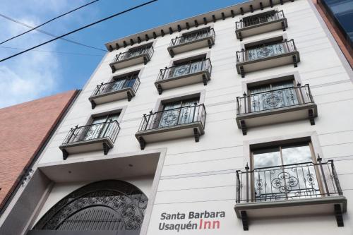 a white building with balconies on it at Hoteles Bogotá Inn Santa Bárbara Usaquén in Bogotá