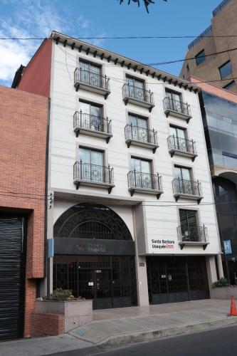 a white building with balconies on a street at Hoteles Bogotá Inn Santa Bárbara Usaquén in Bogotá