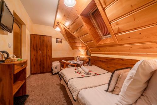 a bedroom with two beds in a room with wooden ceilings at Willa u Zwijaczy in Zakopane