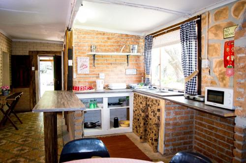 a kitchen with a brick wall and a counter at Shangrila-innibos Country Lodge in Hartbeespoort