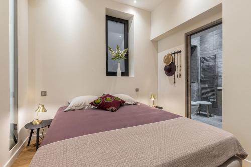 une chambre avec un grand lit et une fenêtre dans l'établissement Cosy Cocoon Place du Pin, à Nice