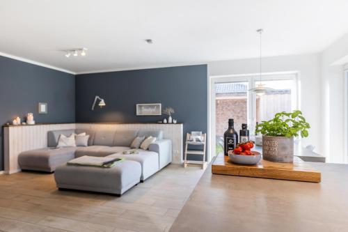 a living room with a couch and a table at lovely&cool STIL-HAUS in Fehmarn