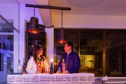 Hotel Kachi de Uyuni في أويوني: يجلس رجل وامرأة في بار مع المشروبات