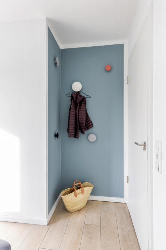 a hallway with a blue wall and a basket at lovely&cool STIL-HAUS in Fehmarn