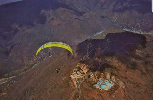 una visione aerea di un parapendio che vola sopra una montagna di La Mansion Hostel a San Gil