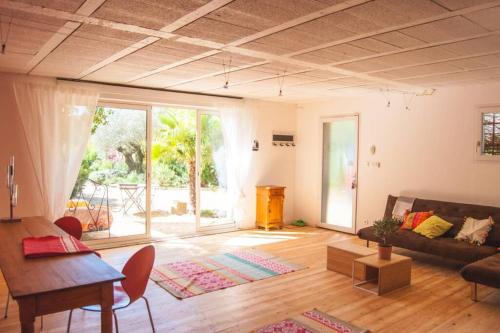 a living room with a couch and a table at Ecrin de verdure avec accès piscine en plein Aix in Aix-en-Provence