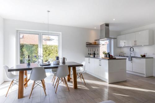 a kitchen with a table and chairs in a room at lovely&cool STIL-HAUS in Fehmarn
