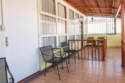 a balcony with chairs and a table in a building at Casa Hotel Sura in San José