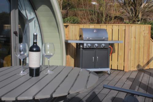 a bottle of wine sitting on a table with two wine glasses at Lough Erne Glamping Pod in Enniskillen