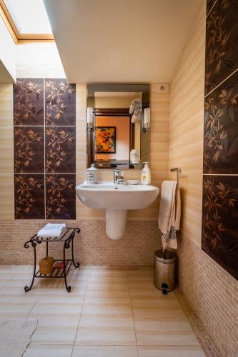 a bathroom with a sink and a mirror at Daiconi Boutique House in Miniş
