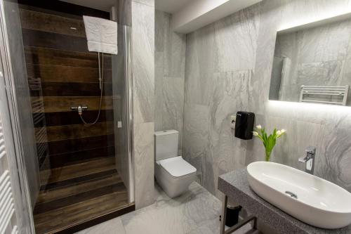 a bathroom with a sink and a toilet and a shower at Hotel Novy Kastiel - Self check-in in Topoľčany