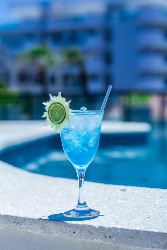 a drink in a glass with a lime in it at Nova Onda Hotel in Cabo Frio