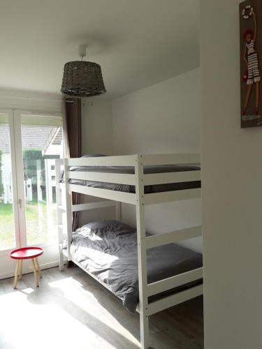 une chambre avec deux lits superposés et une fenêtre dans l'établissement Agon-Coutainville, Villa spacieuse à 250m de la mer, à Agon-Coutainville