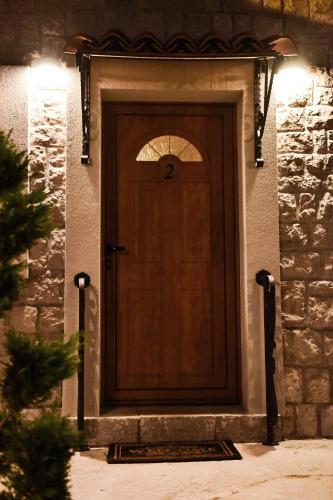a wooden door on a stone house with lights at Apartments Monte Green in Virpazar