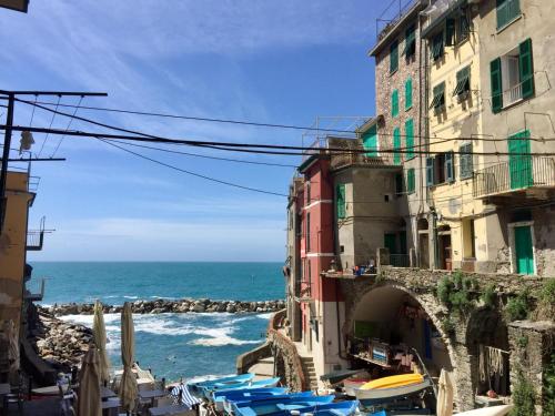 a view of a beach with umbrellas and the ocean at Sara Apartment, Comfort and lateral sea view in Riomaggiore