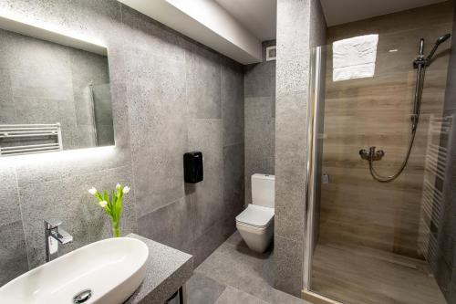 a bathroom with a toilet and a sink and a shower at Hotel Novy Kastiel - Self check-in in Topoľčany