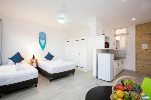 a room with two beds and a bowl of fruit at Ocean Zen Suites on 5th Avenue - Adults Only in Playa del Carmen