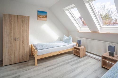 a bedroom with a bed and two windows at K 357 - Low budget Hotel in Ratekau bei Lübeck in Ratekau