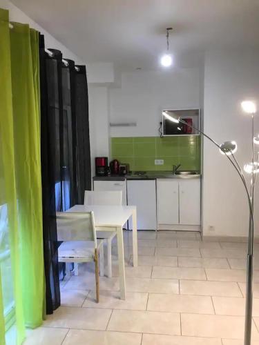 un salon avec une table et une cuisine dans l'établissement Superbe & LUXURY studio Paris Montreuil, à Montreuil