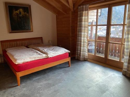 a bedroom with a bed and a large window at Ferienhaus Wilder Kaiser in Kiefersfelden