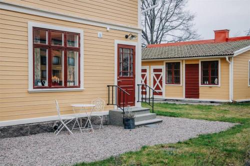a house with a red door and a table and chairs at Casa Fontenay charmig lägenhet nära stadsparken och Vättern in Hjo