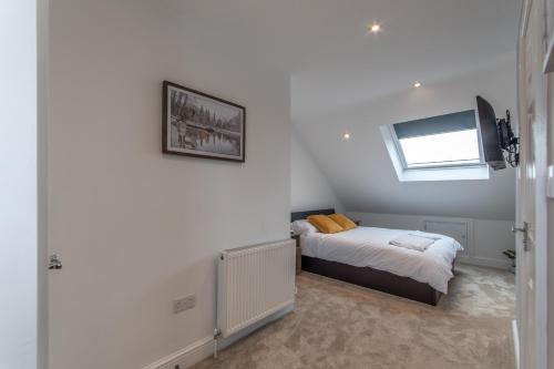 a bedroom with a bed and a tv on a wall at Super cosy self-catering studio flat in Gillingham