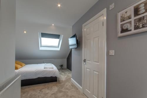 a bedroom with a bed and a window and a door at Super cosy self-catering studio flat in Gillingham