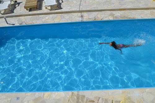 a man is swimming in a swimming pool at Pousada Colonetti in Lindóia
