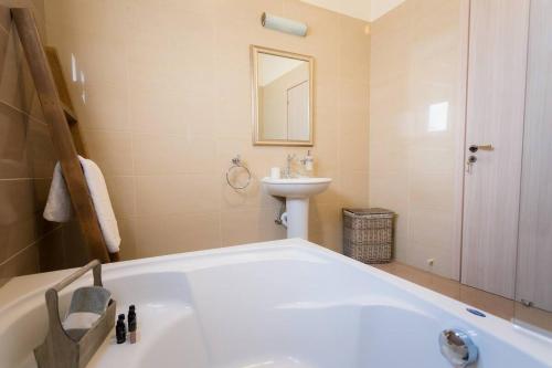 a bathroom with a bath tub and a sink at Grand Mansion Countryhouse & Spa in Phrenaros