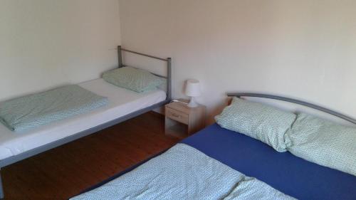 a bedroom with two beds and a night stand with a lamp at Monteurhaus LK1 in Lissendorf