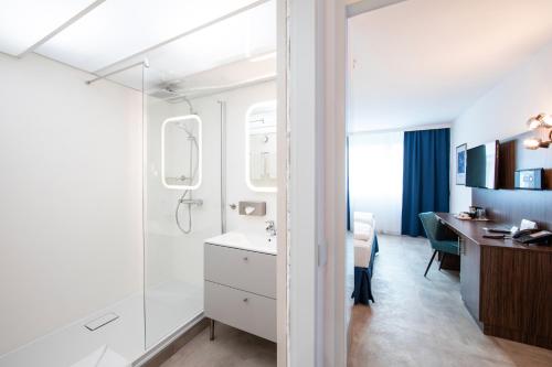 a bathroom with a sink and a desk at SLEEEP Hotel Vösendorf in Vösendorf