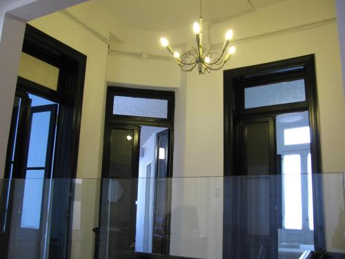 comedor con 3 ventanas y lámpara de araña en 06 Soho Suites en Buenos Aires