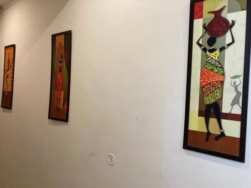 a painting of a woman on a wall at Hotel Arrow 19 in Bareilly