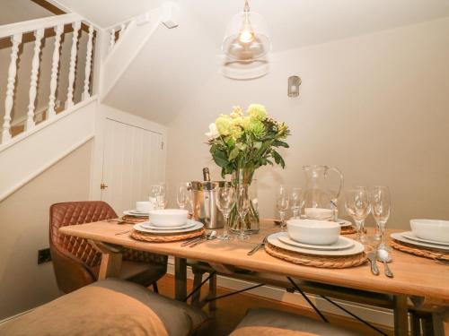 a dining room table with a vase of flowers on it at Brookhouse in Castleton