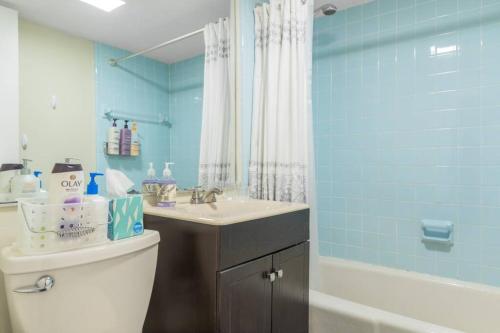 a bathroom with a toilet and a sink and a tub at Parking - Private Entrance - King Beds in Boston