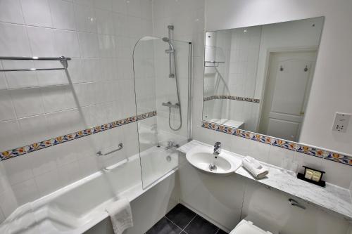 a bathroom with a shower and a sink and a tub at Quorn Grange Hotel in Loughborough