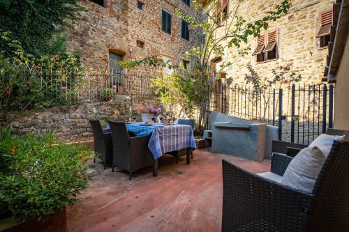 a patio with a table and chairs and a building at Casa Collodi Castello in Collodi
