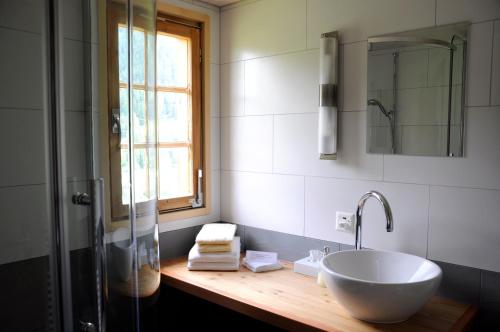 uma casa de banho com um lavatório e uma cabina de duche em vidro. em Hotel Tenne em Reckingen - Gluringen