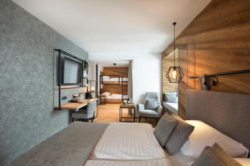 a hotel room with a bed and a television at Hotel Edelweiss in Saalbach Hinterglemm