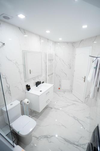 a white bathroom with a toilet and a sink at SHIMresidence LUXURY in Rădăuţi