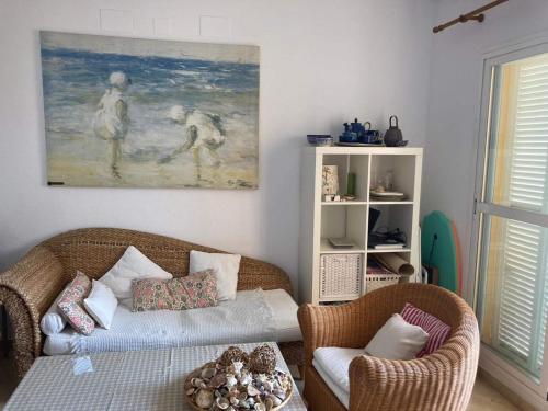 a living room with a couch and two chairs and a painting at Apartamento Ailem in Novo Sancti Petri