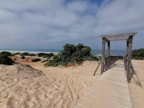 a wooden walkway on a sandy beach next to the ocean at Apartamento Ailem in Novo Sancti Petri