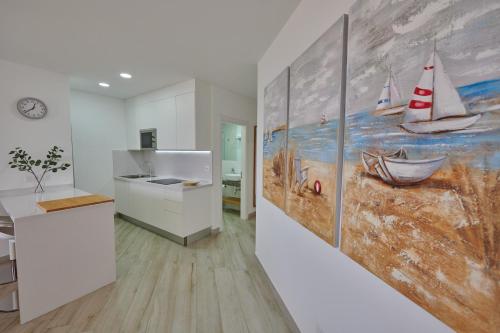 a kitchen with a painting of boats on the wall at ABLANCAS - La Restinga in La Restinga