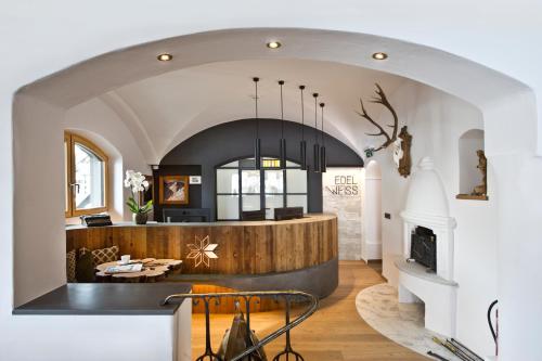 a living room with an archway and a fireplace at Hotel Edelweiss in Saalbach Hinterglemm